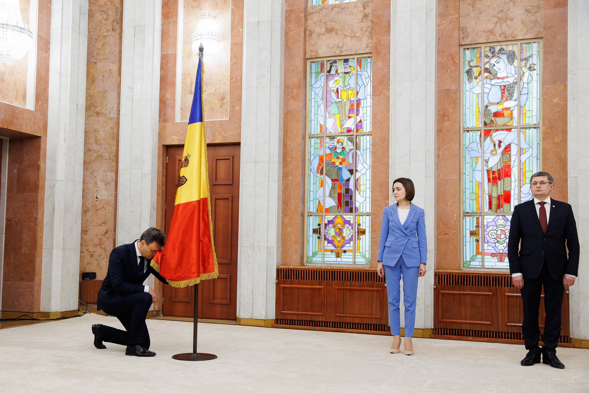 Maia Sandu, with her newly-appointed Prime Minister Dorin Recean (kneeling)